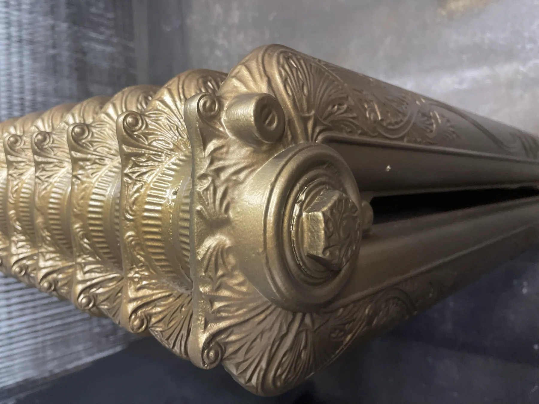 Close-up of the aged gold finish on an ornate cast iron radiator from the Municipal Hotel